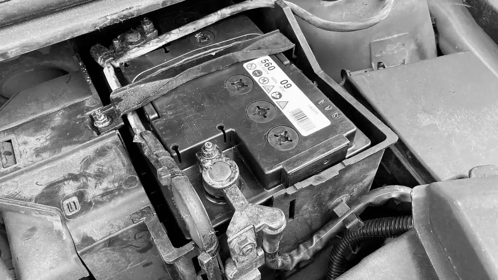 A technician fitting a replacement car battery