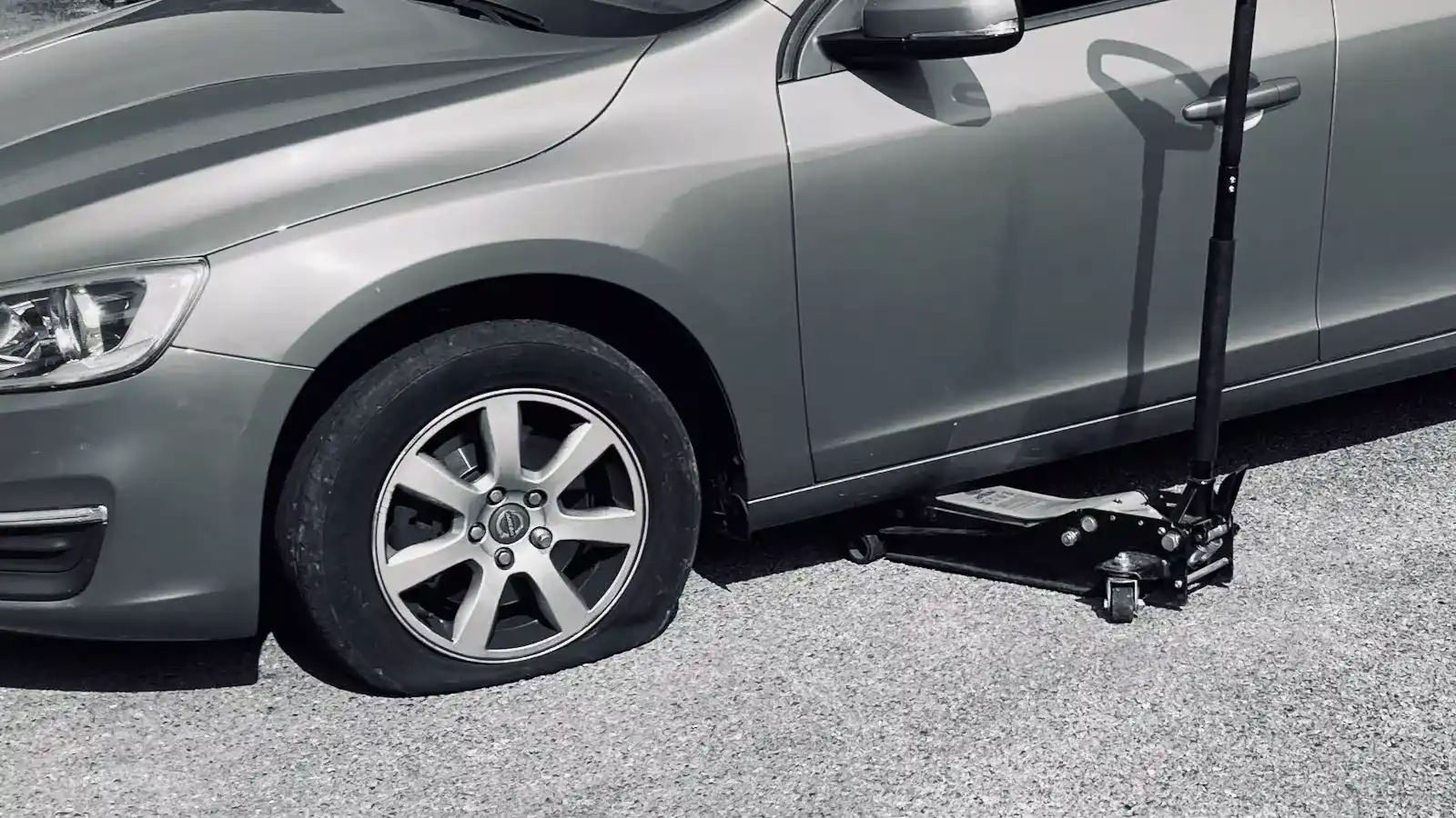 A technician repairing a punctured car tyre using a mobile puncture repair kit